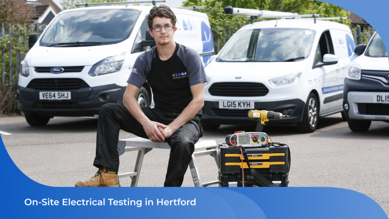 AC1 Electrical Services technician holding tools with company-branded vans parked in the background.